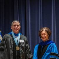 Provost Mili smiles next to man